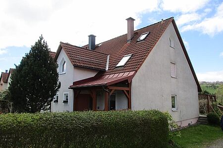 Weißes Wohnhaus mit grau-verschmutzter Fassade