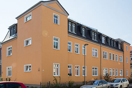 Mehrfamilienhaus mit orange gestrichener Fassade