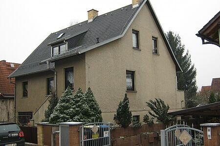 Zweifamilienhaus mit brauner Fassade vor der Sanierung