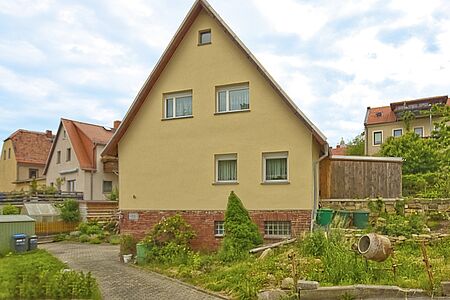 Einfamilienhaus mit verklinkertem Fundament und gelber Fassade