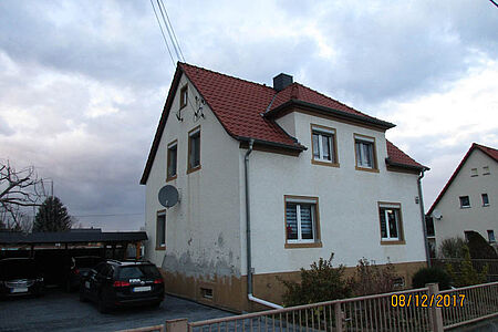 Weißes Wohnhaus mit Stockflecken auf der Fassade